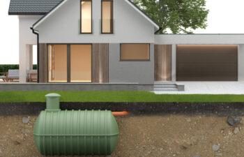 House with large windows and attached garage. A cross-section shows an underground septic tank with piping leading to the house. Grass and tree in the background.